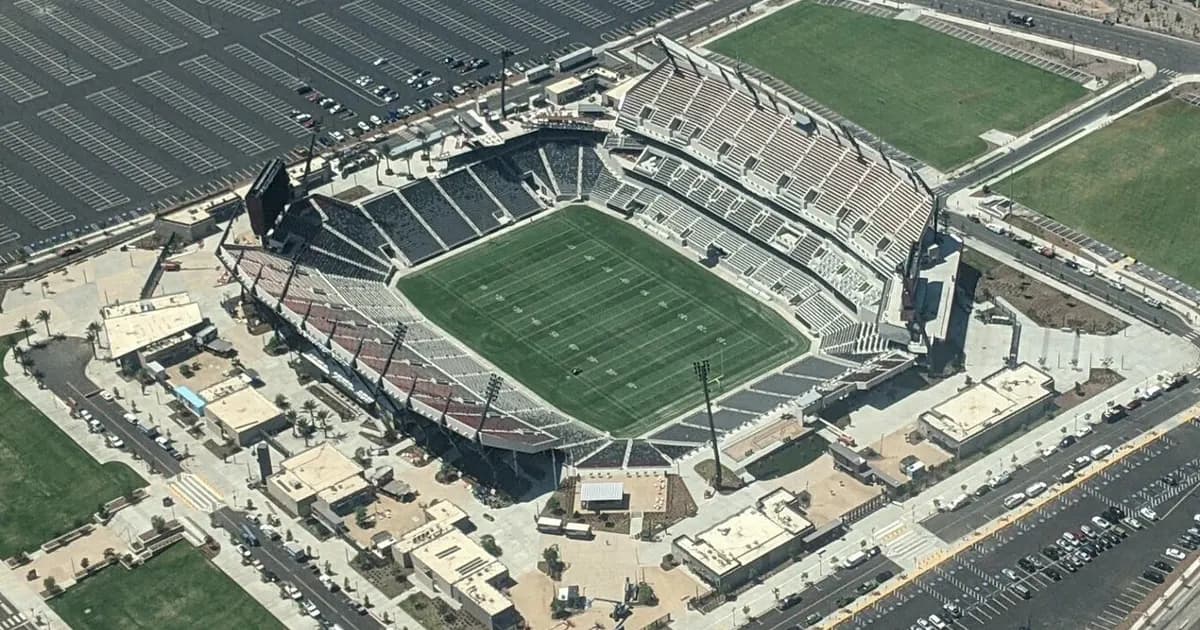 General view of a football stadium with empty seats and pitch lights on before kickoff